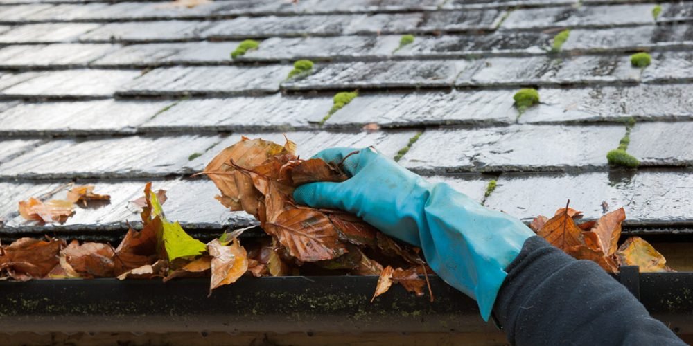 Image of eavestrough being cleaned of debris.